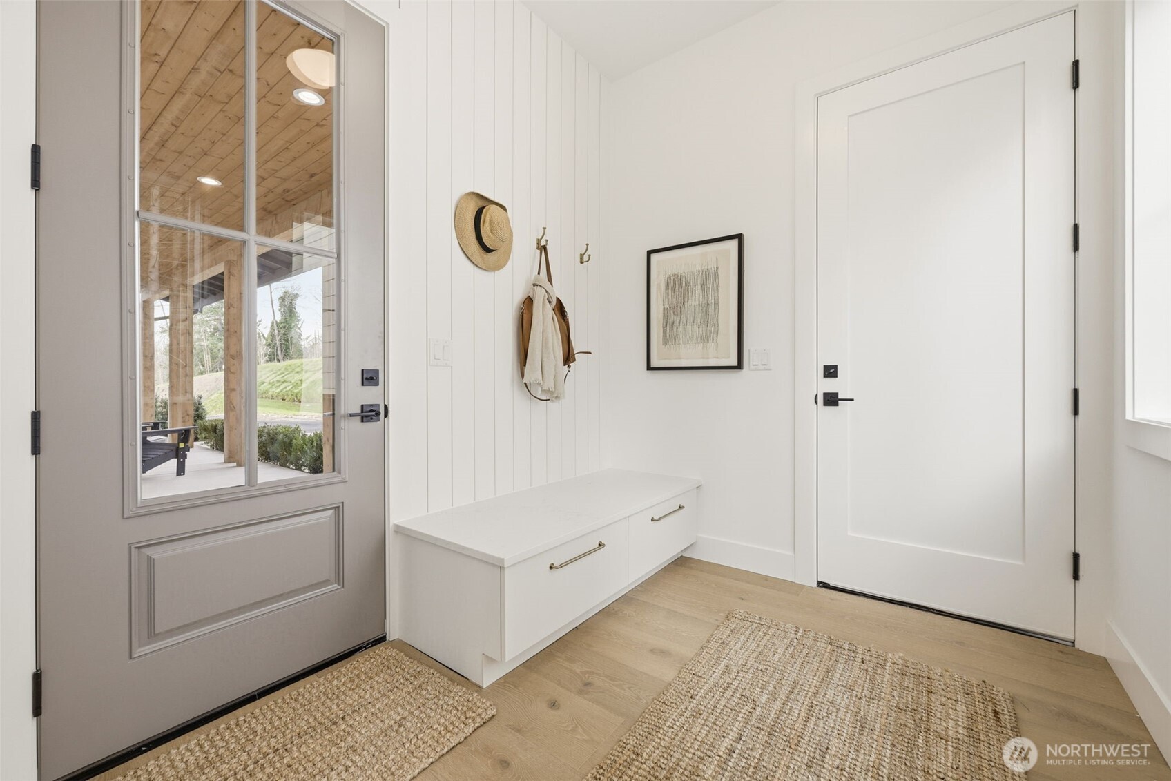 Entrance off the garage is equipped with functional and aesthetic storage