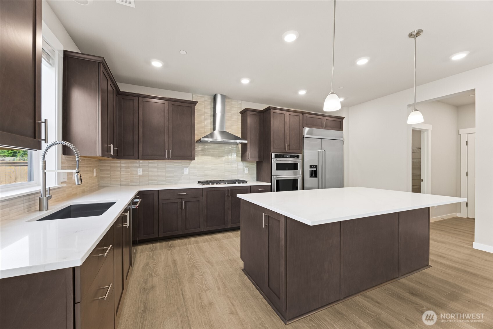 Well-appointed kitchen with gas cooktop, huge pantry adjacent to mud room just off the garage.  48" counter depth side-by-side refrigerator.  Plenty of space to entertain! Cabinet color may be different than actual home.