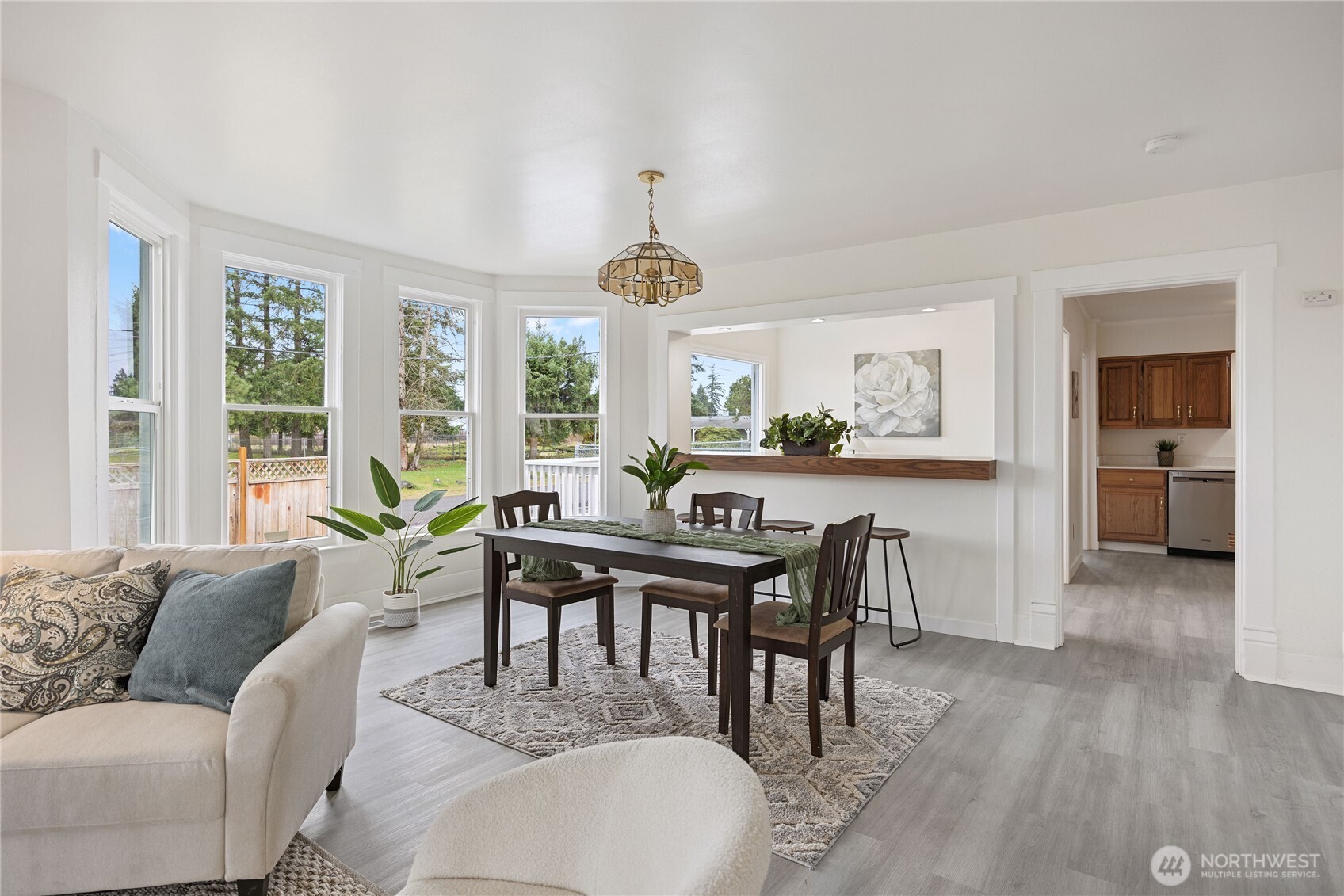 Bright and cheery living space is lined with windows letting sunshine in.