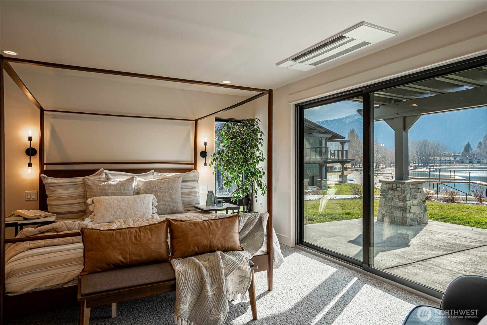 Primary bedroom with large glass sliding door opens to the lakefront patio.