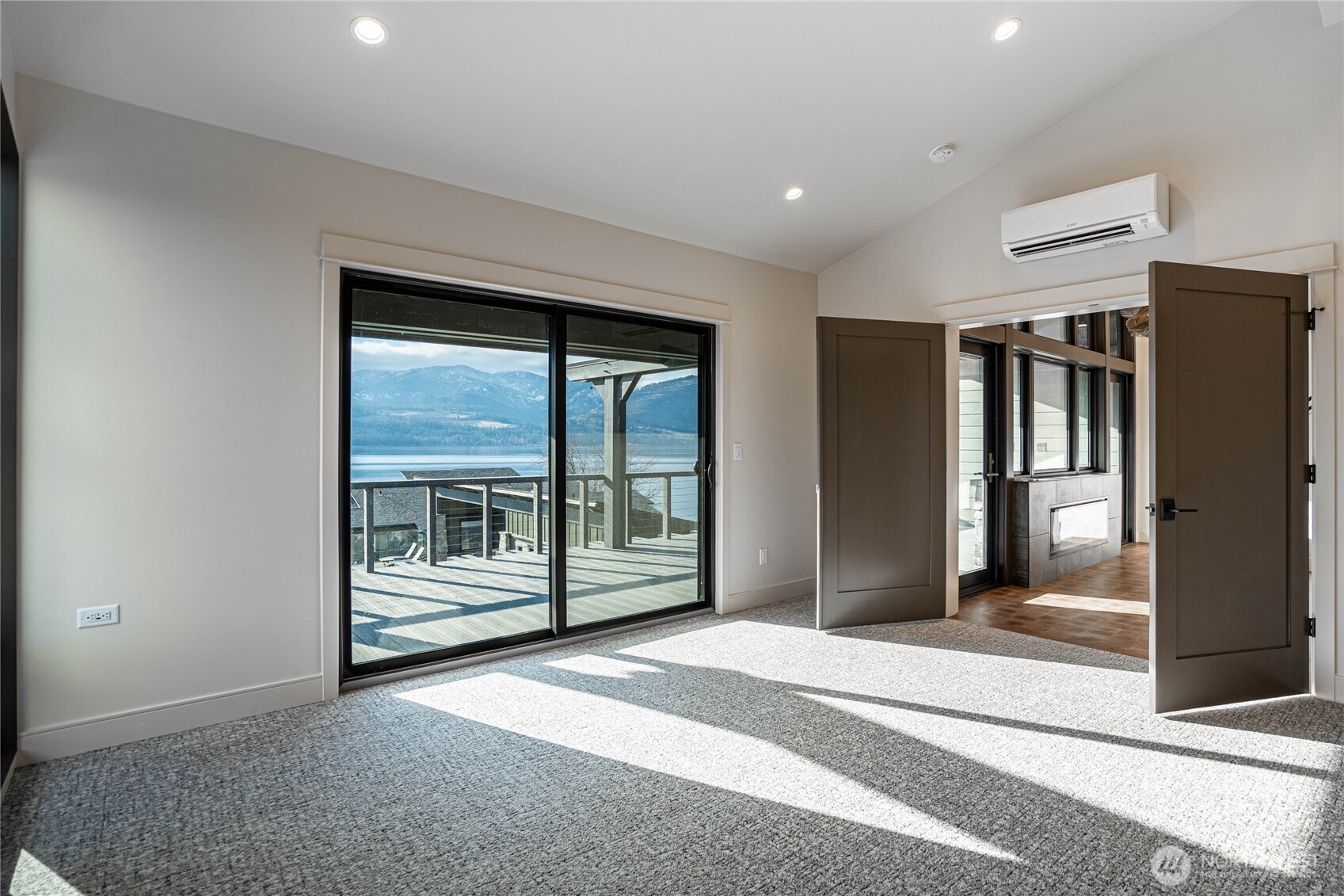 Primary bedroom with large glass sliding door opens to the deck overlooking the community pool.