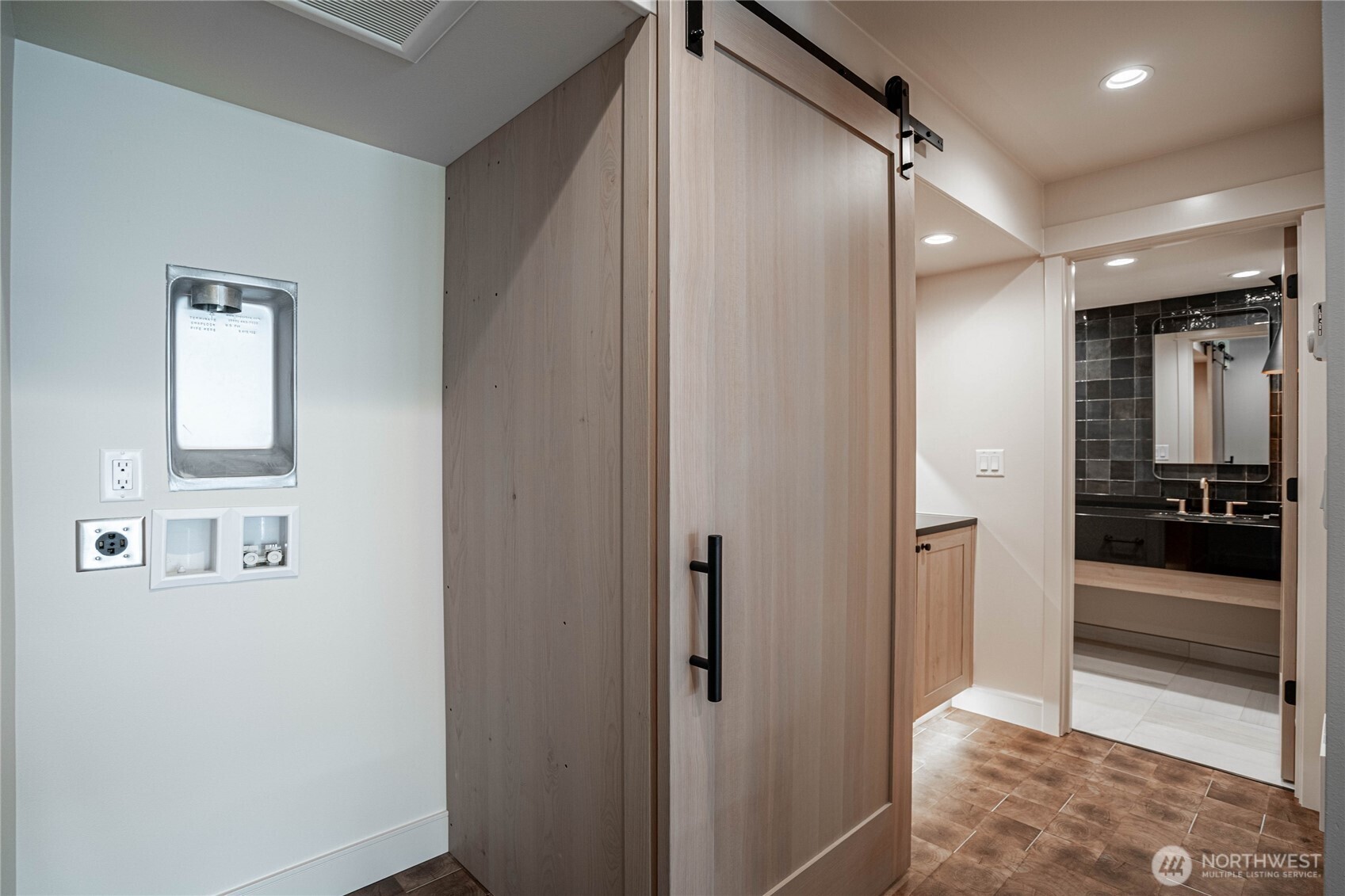 Sliding door conceals the stacking washer/dryer laundry area near the guest bathroom.