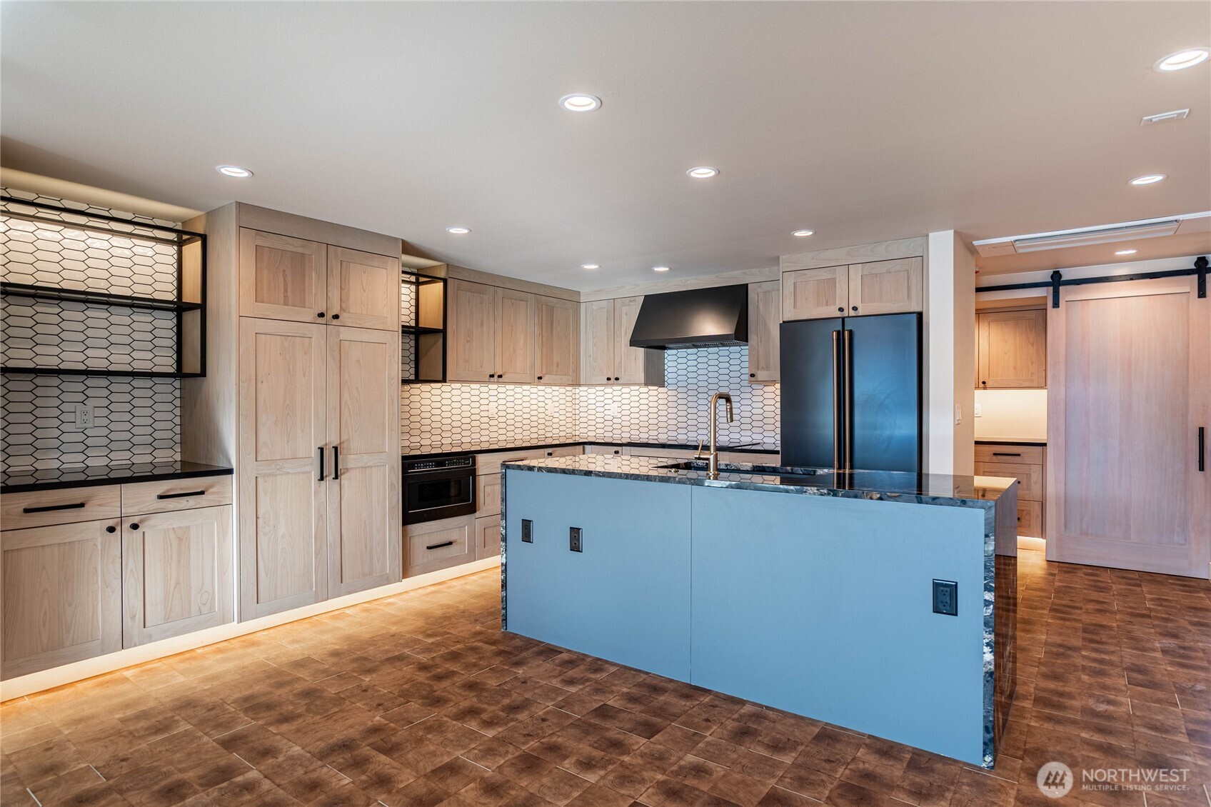 Modern kitchen counters and luxury appliances accented by automatic undercounter and undercabinet lighting. Ample kitchen storage space.