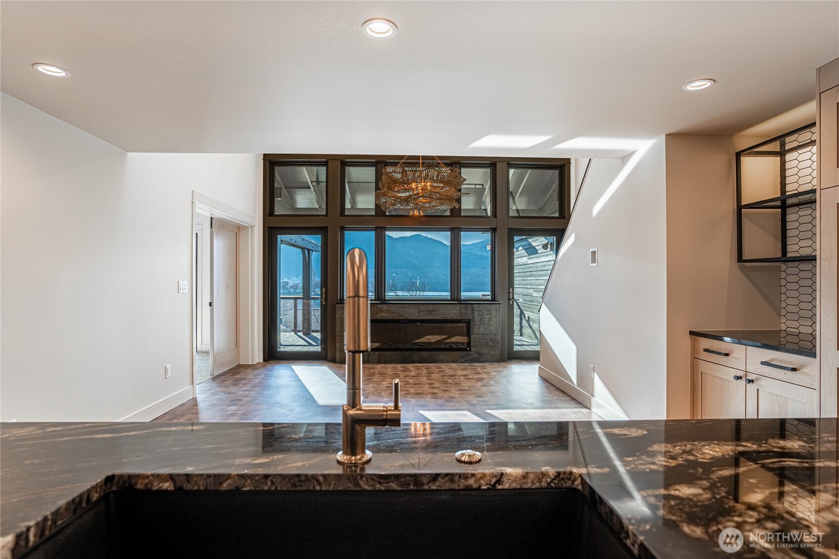 Striking solid slab marble kitchen counters and stylish gold fixtures are highlights in the kitchen with lake views always in sight.