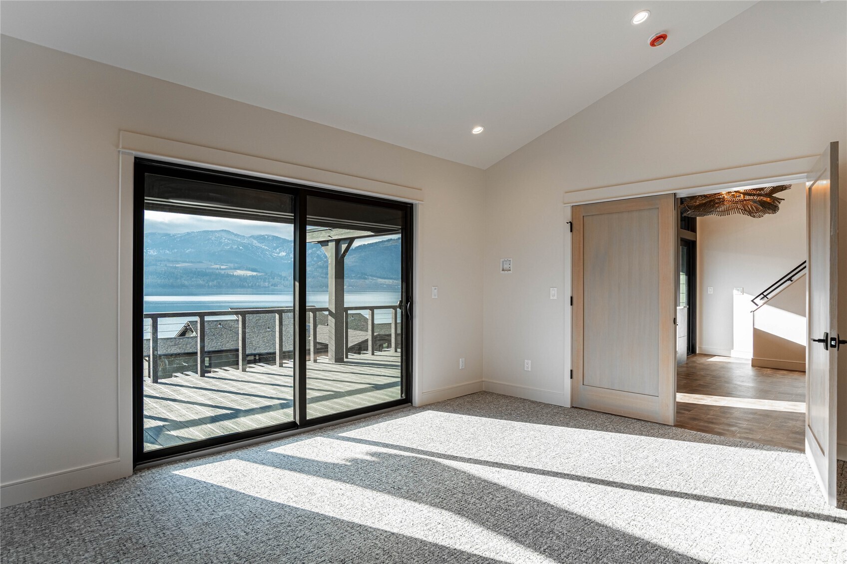 Primary bedroom with large glass sliding door opens to the large deck.