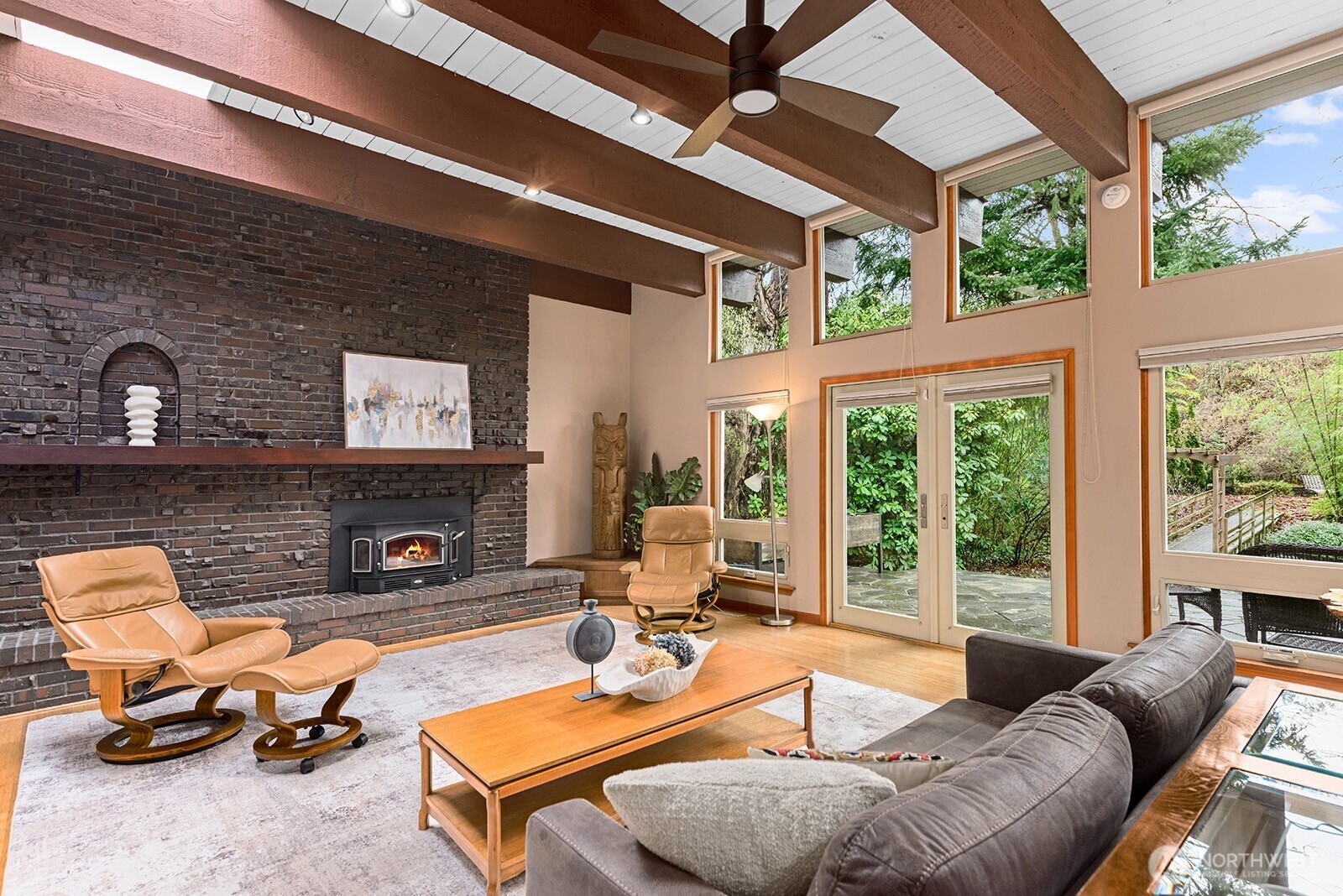 A dramatic brick wall and functioning wood stove anchor the less formal areas of the great room. The built-in cabinet in the corner makes a perfect TV stand for this room to serve as the media room.