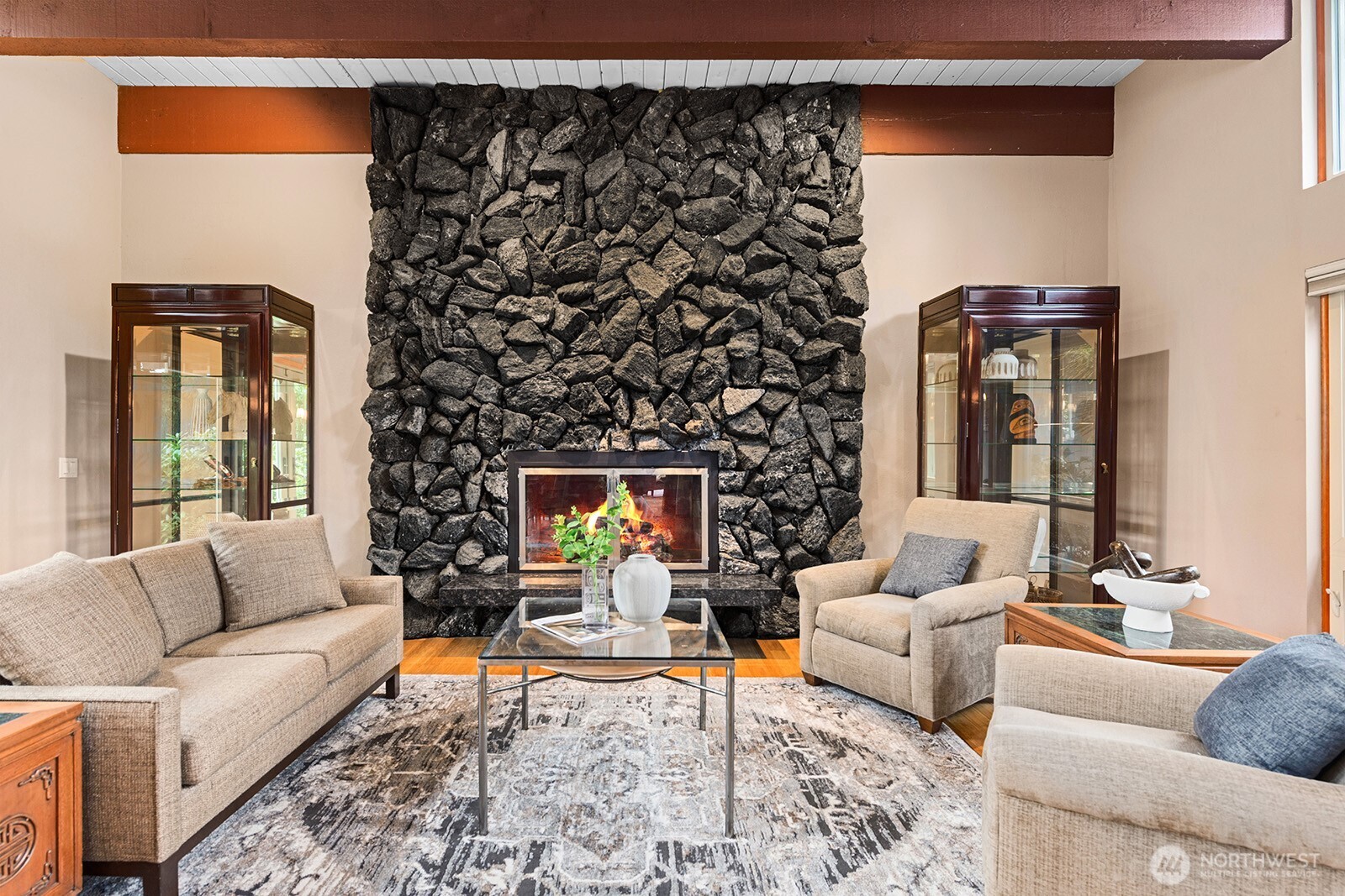 The formal living room is anchored by the imposing black pumice gas fireplace.