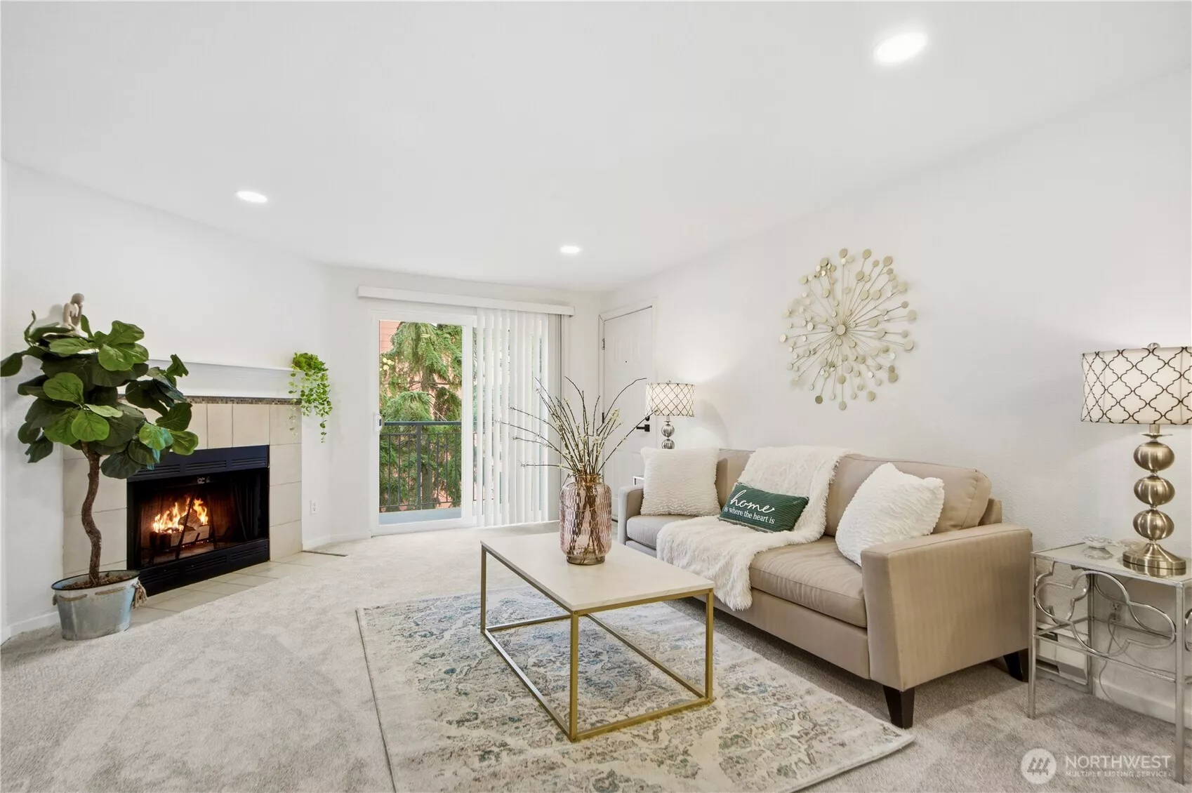 Bright and inviting living room with fresh paint, updated flooring, and a cozy wood-burning fireplace.