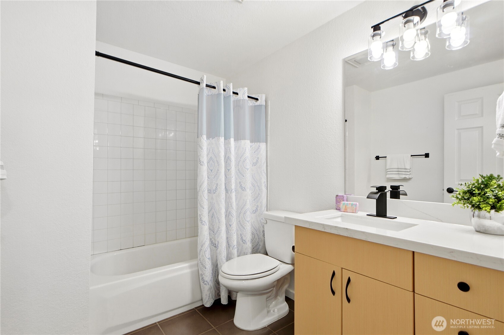Second bathroom featuring updated countertop and modern lighting.