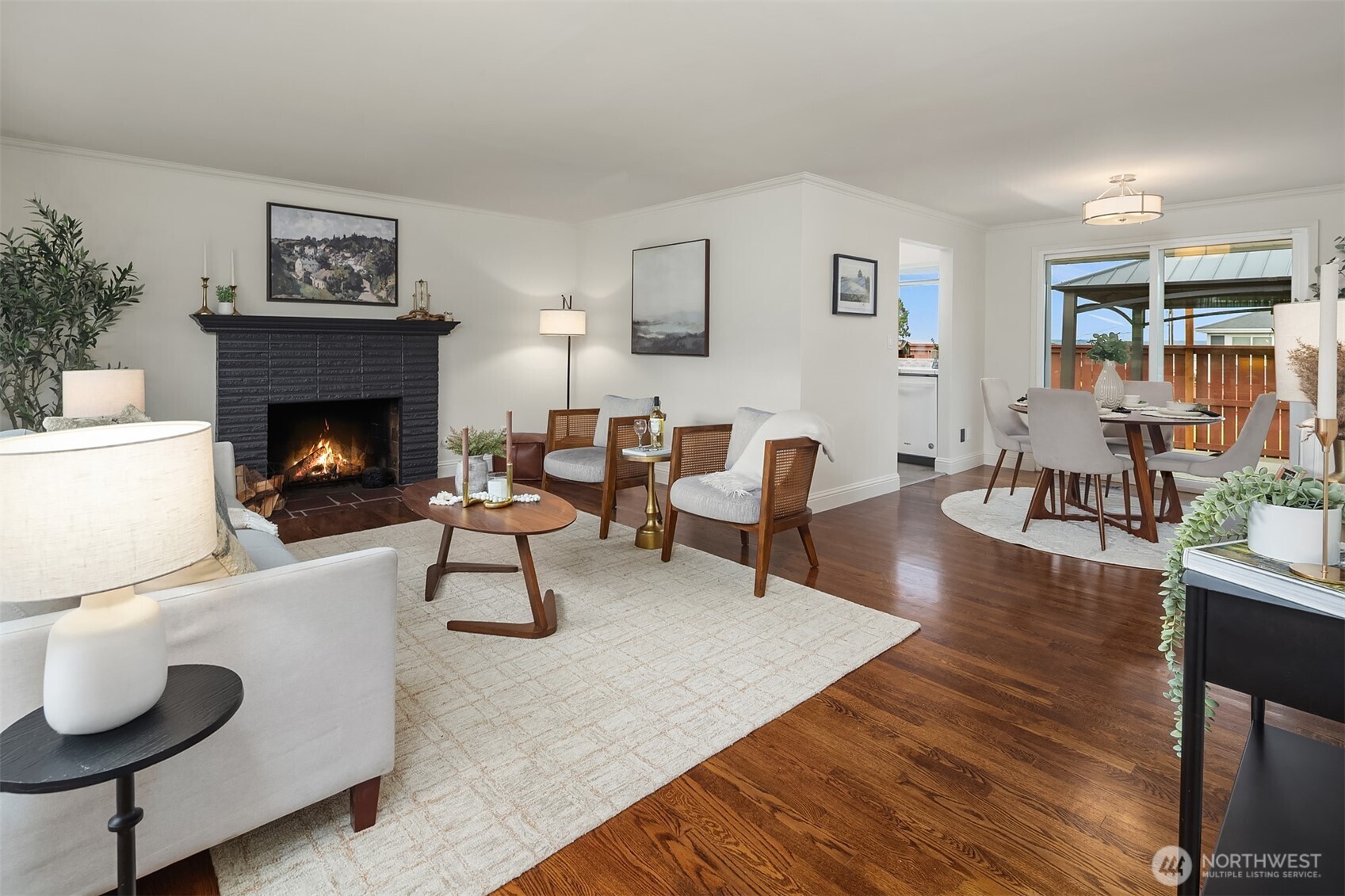 Living space with gas fireplace (fire added for effect, buyer to verify functionality), showcasing sliding glass doors off of dining room.