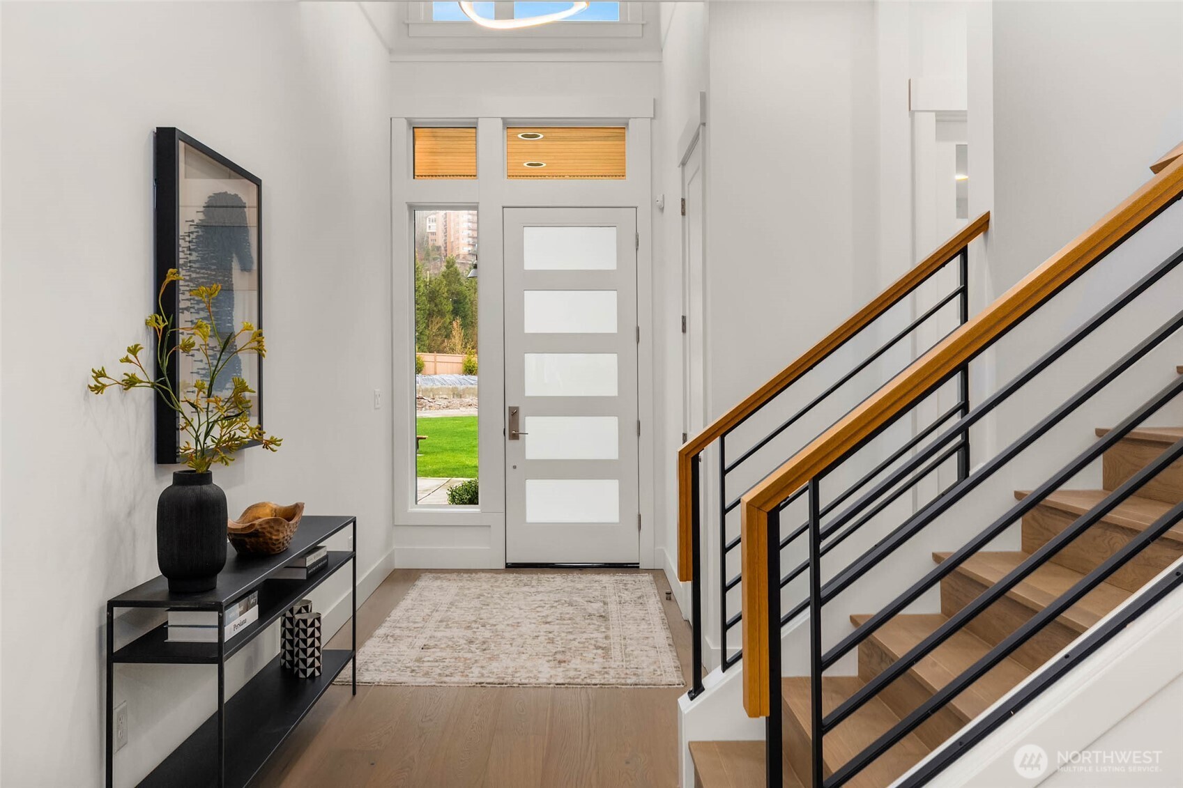 Vaulted ceilings with designer selected chandelier and contemporary and thoughtful windows create a welcoming entry foyer