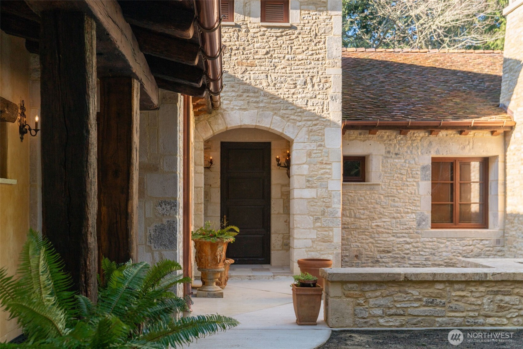 Entry courtyard framed by limestone walls and classic European detailing.