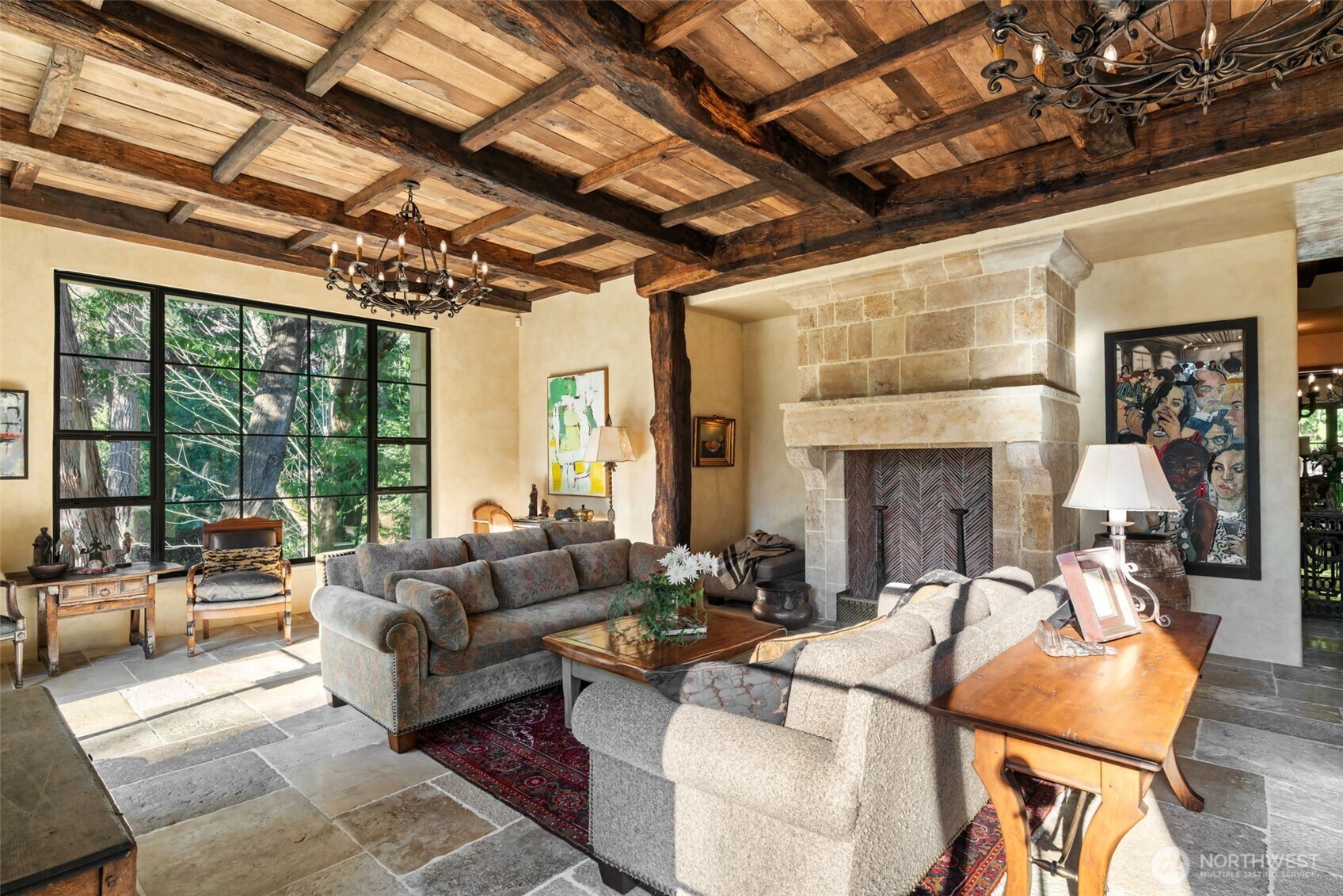 A refined gathering space where historic materials and modern comfort coexist seamlessly. A striking fireplace crafted from reclaimed French limestone anchors the room.