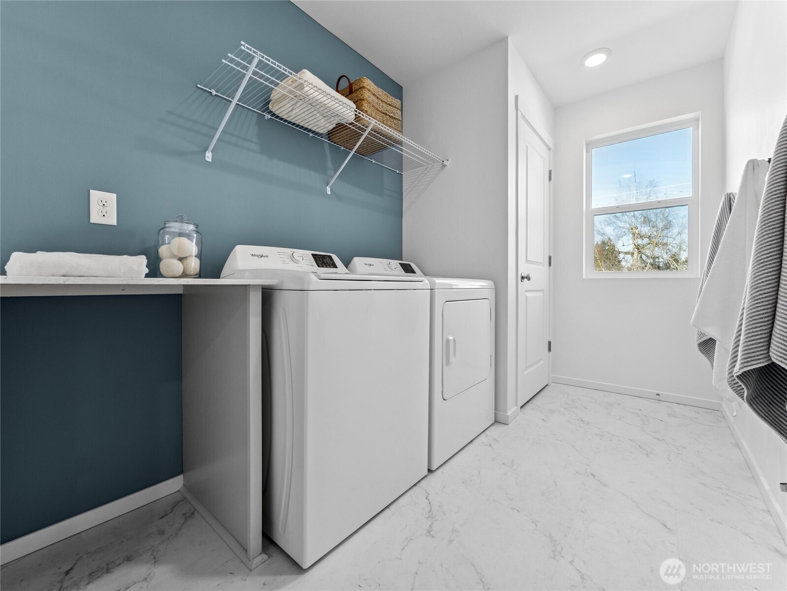 Upstairs laundry room with a folding table and closet for the water heater.  Picture for representational purposes only, colors and features may vary.