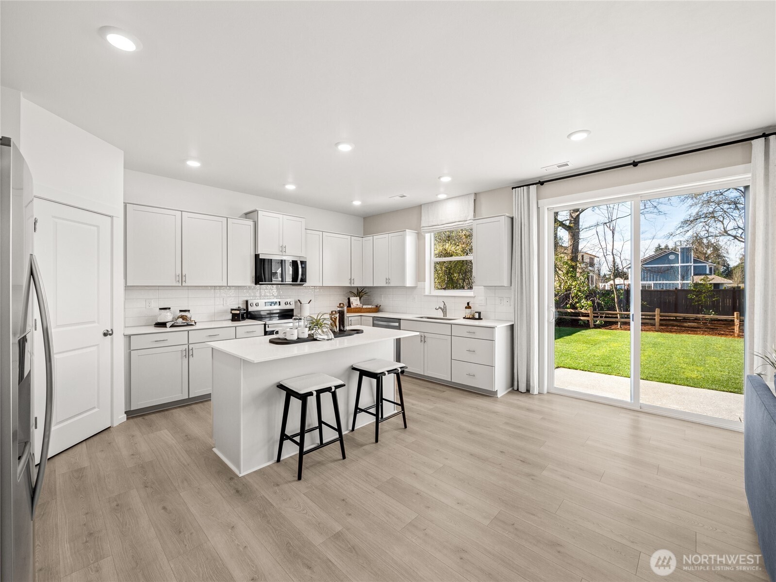 Open island kitchen with slab quartz counters, full height tile backsplash, soft-close cabinetry, and a walk in pantry.  Picture for representational purposes only, colors and features may vary.