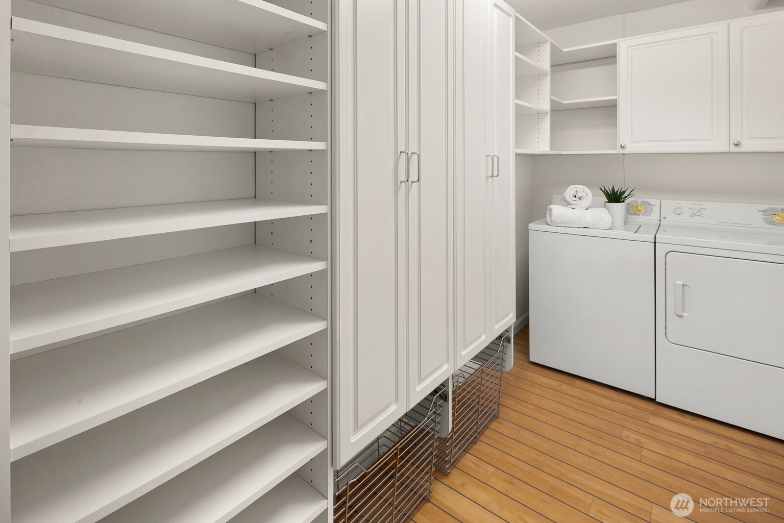 In-unit laundry and storage room with custom closet system by Closet by Design