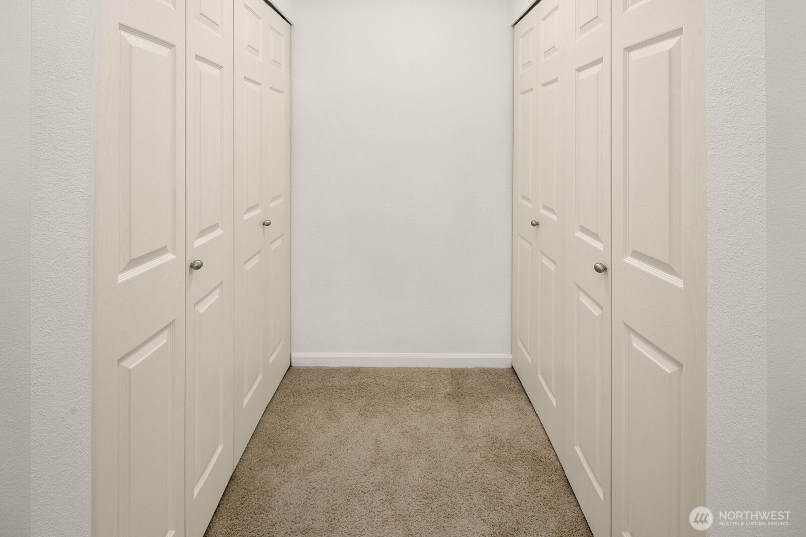 Spacious primary bedroom with bay window and dedicated custom closet area