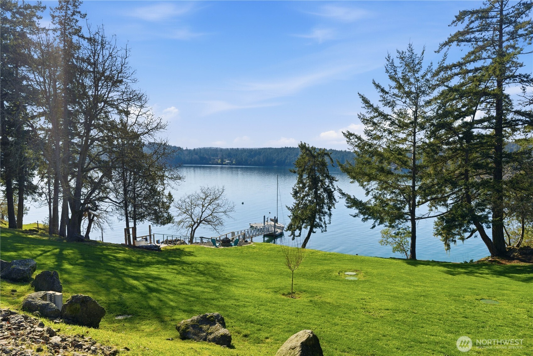 View from the lawn toward the deep-water dock, with two private buoys floating in the protected bay