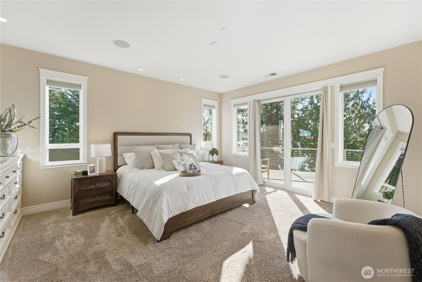 A serene primary bedroom with walk-out deck access showcases never-ending views and spectacular sunsets. The suite continues with a full bathroom, oversized laundry room, generous walk-in closet, and an office