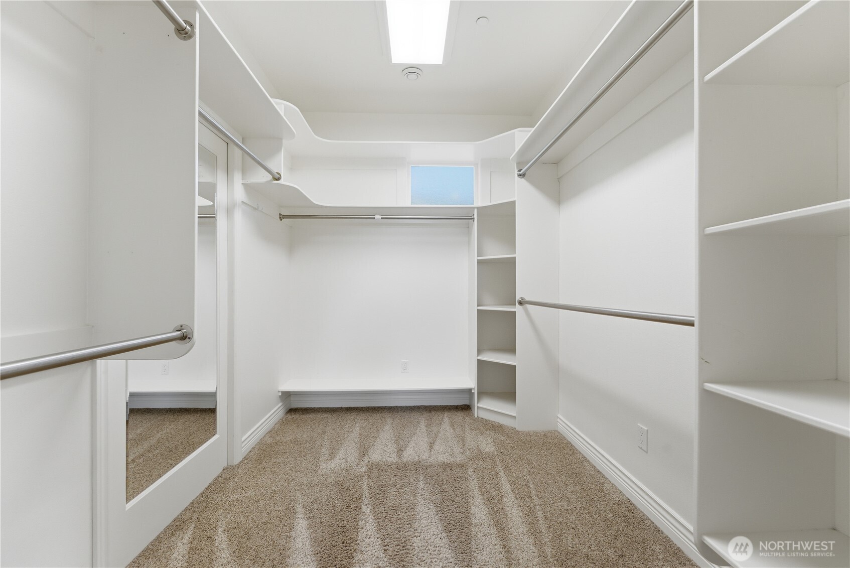 A large, well-appointed walk-in closet anchors the primary suite, offering generous storage and thoughtful organization