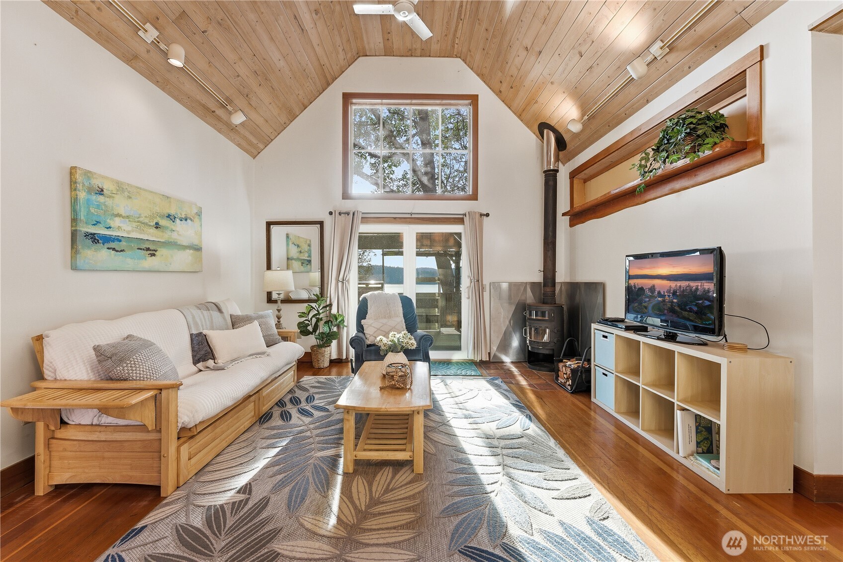 Cottage #1 features vaulted ceilings, a separate main bedroom, and an upstairs loft with a twin bedroom. The full bathroom sits just off the bathroom.  The main living overlooks the calm bay beyond the outdoor kitchen and deck