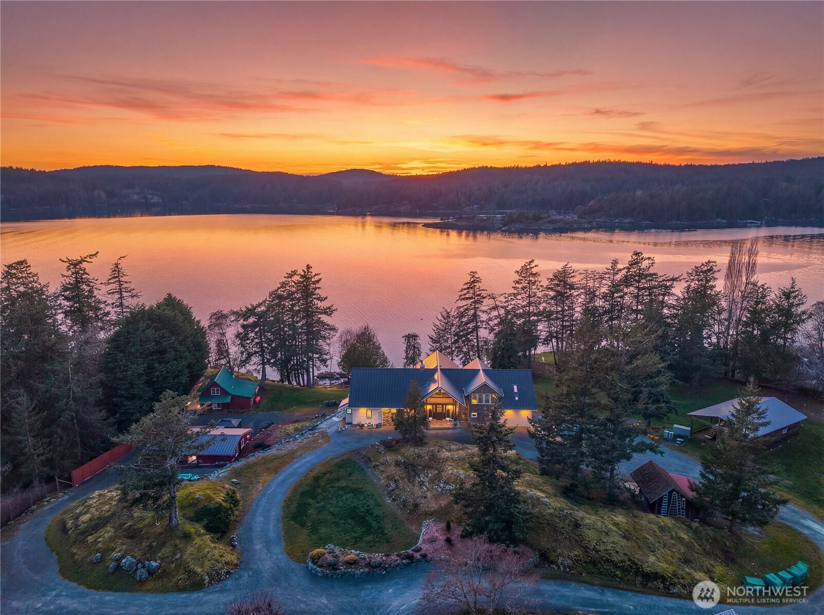 Sunset over Twin Coves, highlighting the protected bay, two guest cottages, RV shelter, and barn.