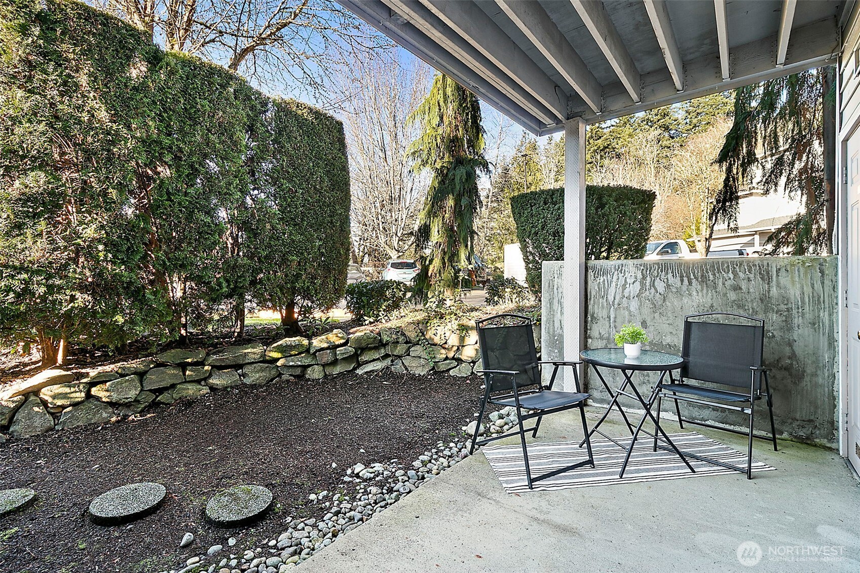 Covered, ground-level patio off living room further extends living space year-round