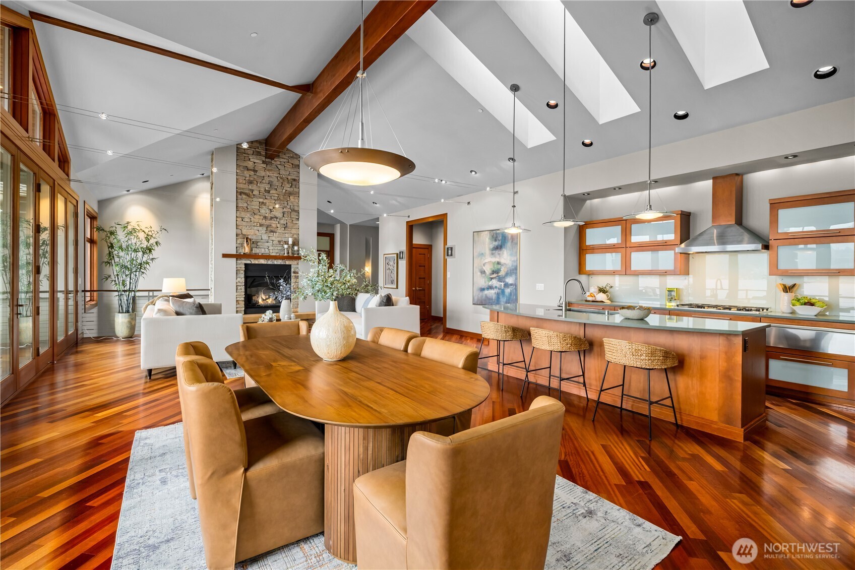 Open-concept living and dining with walls of glass, vaulted ceilings, and seamless access to the waterfront deck.