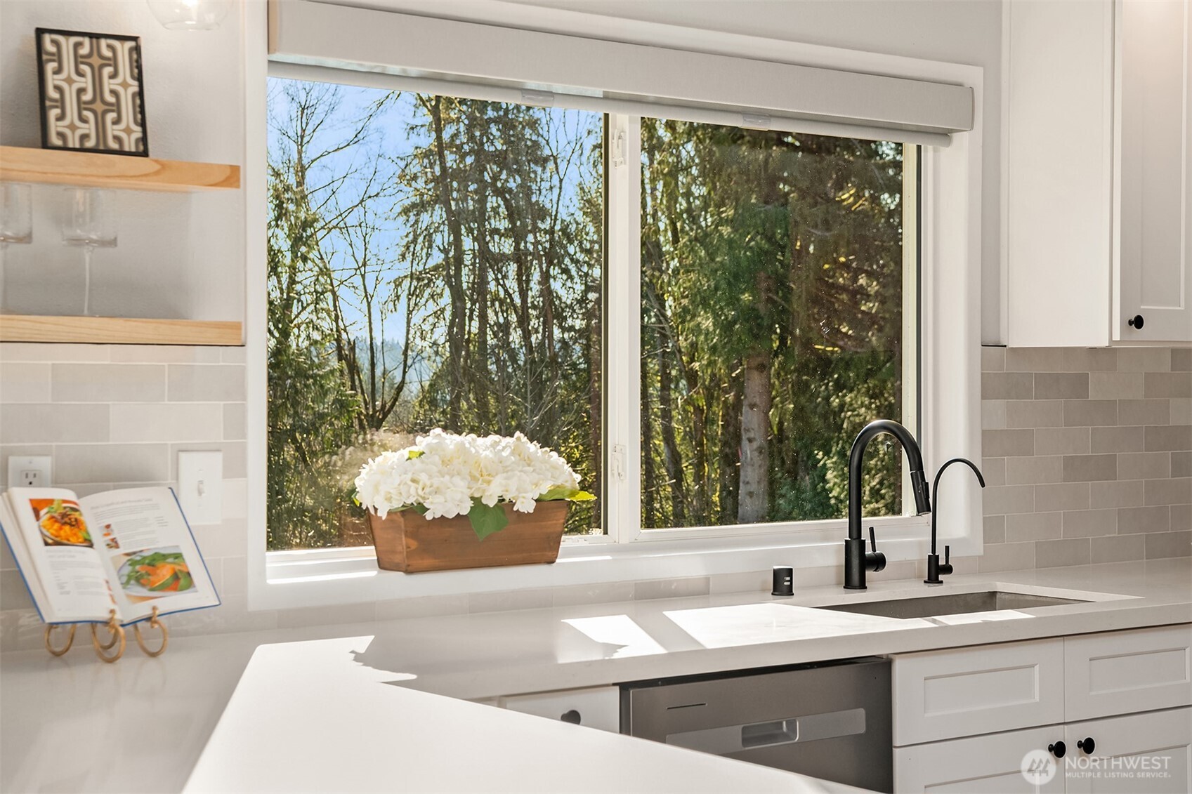 Large primary bedroom with ensuite 3/4 bath on the main floor, staged with a king size bed.