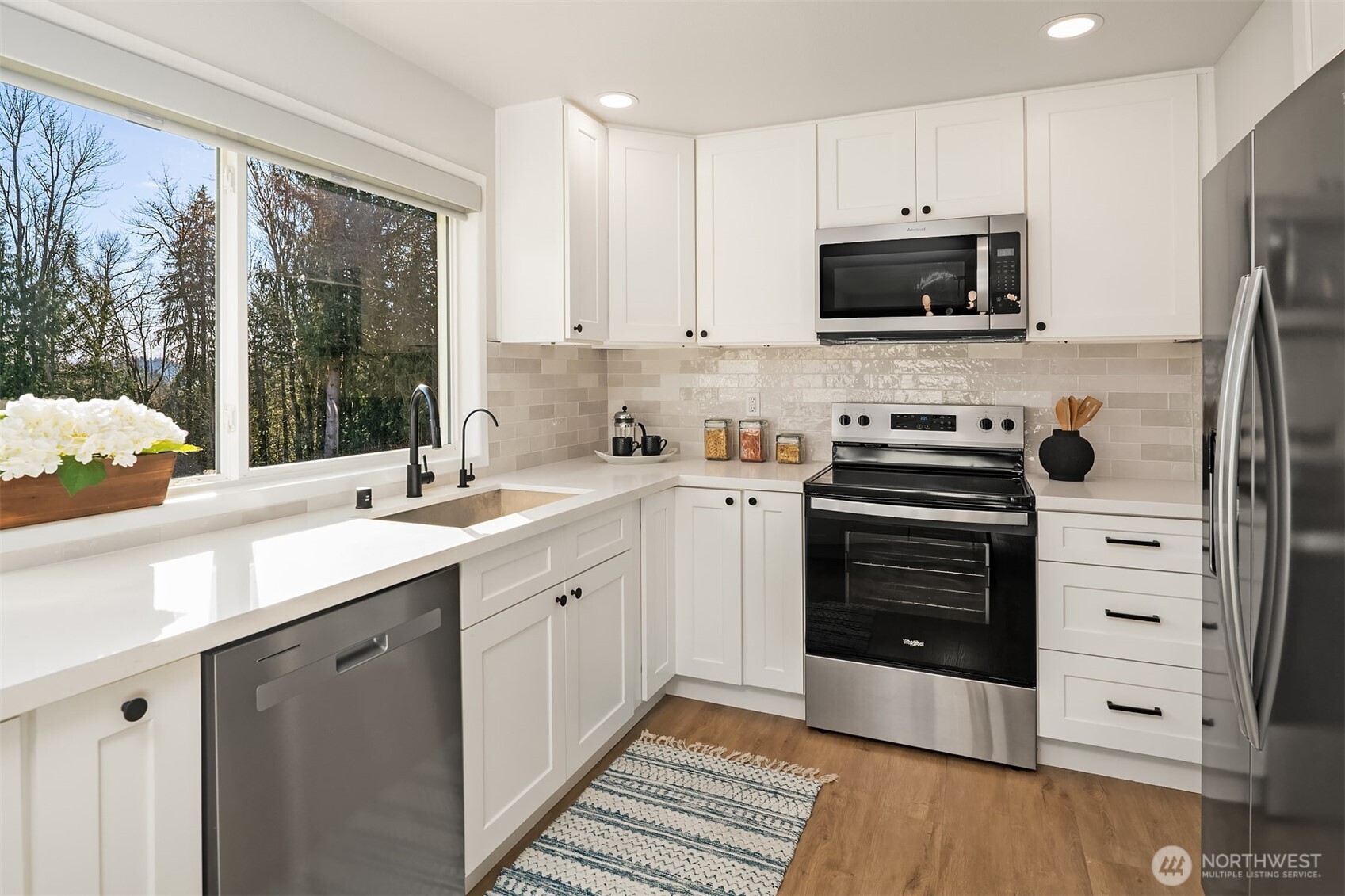 Remodeled kitchen with designer details including modern lighting and floating shelves.