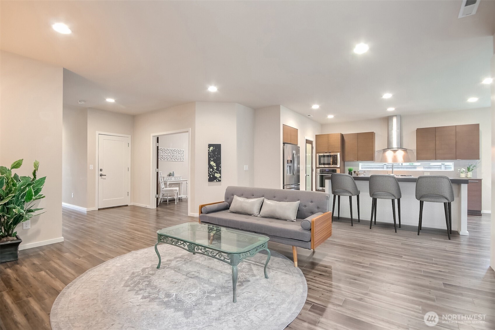 Great room open to kitchen and large slider to covered deck and backyard. Virtual staging with bar chairs