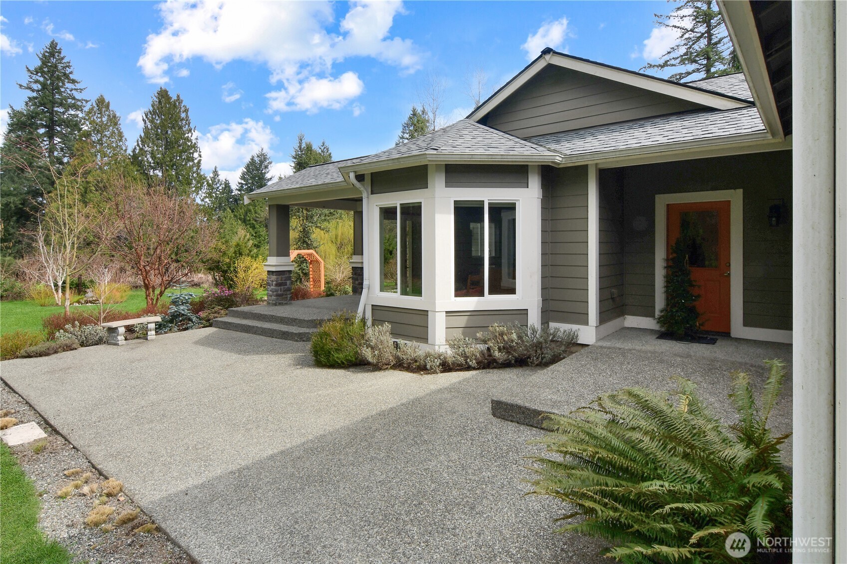 Private patio off rambler with covered entry and landscaped surroundings.