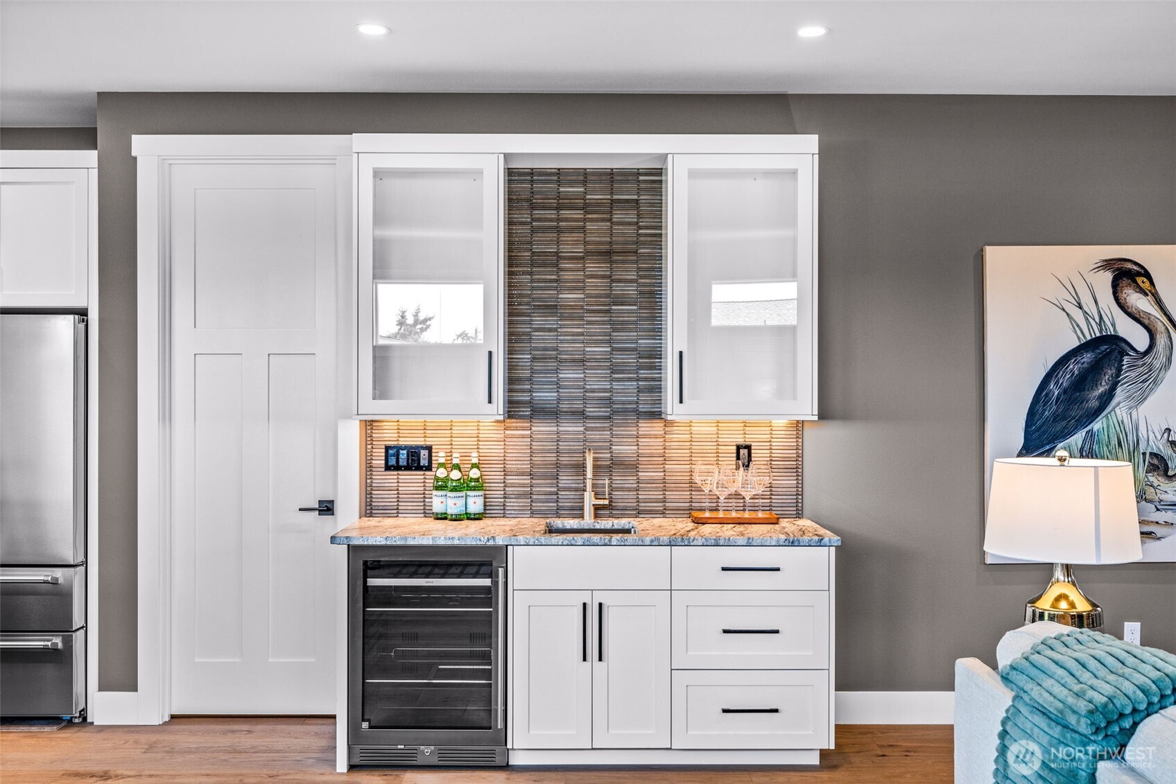 Wet bar with wine refrigerator making it a perfect space or a coffee station, wine service or buffet set up. Door to left leads to the amazing walk in pantry.