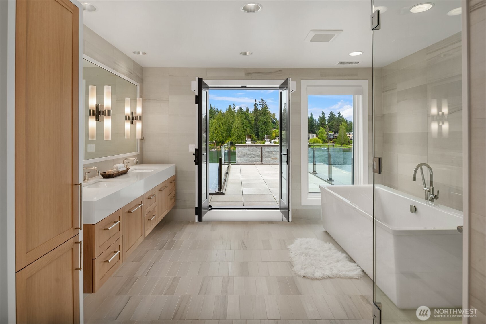 Spa-inspired primary bathroom featuring a freestanding soaking tub, glass-enclosed rain shower, and elegant natural stone finishes.
