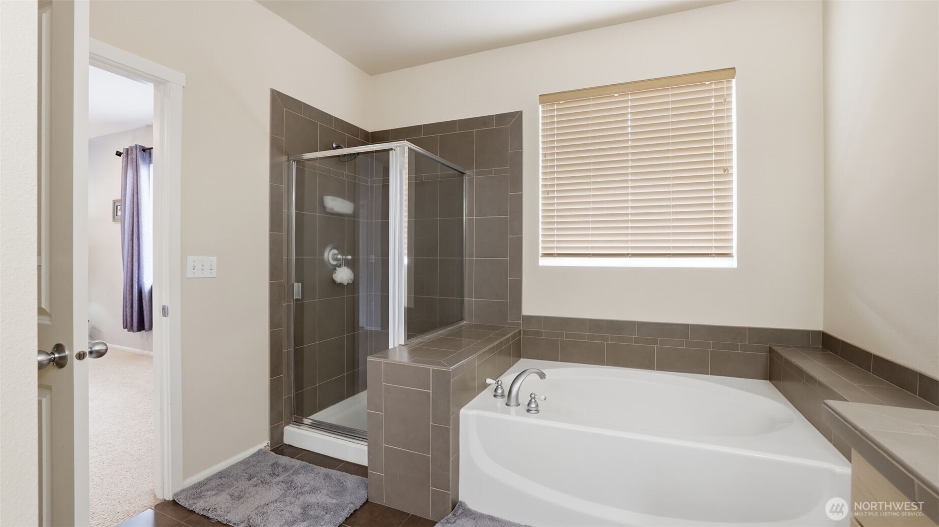 Enjoy a large soaker tub plus walk-in shower in this primary en suite.