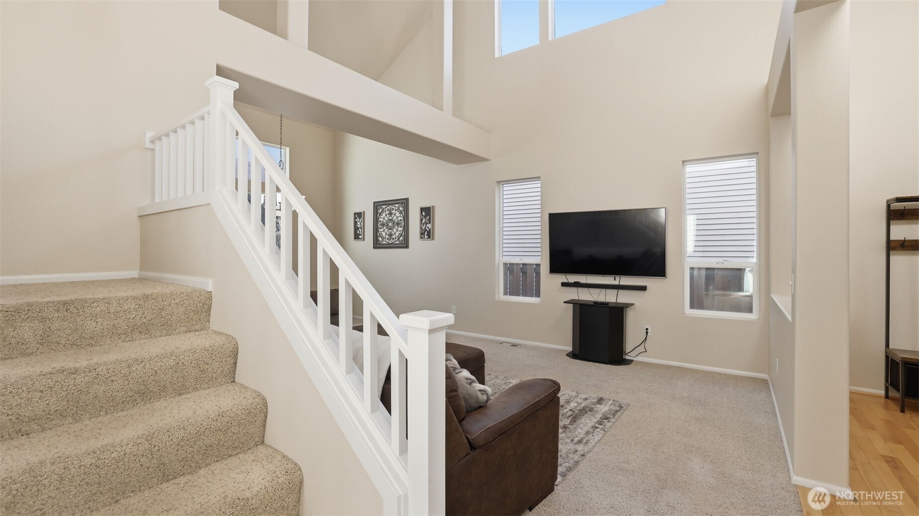 Spacious front living area featuring tall ceilings, soft carpeting, and an open layout perfect for everyday living.