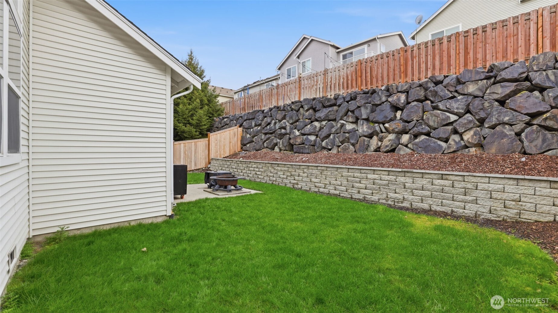 Backyard designed for comfort and connection, complete with a fire pit gathering spot.
