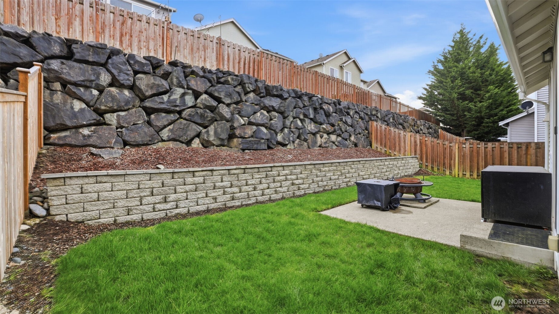 A low-maintenance backyard offering open lawn and a peaceful setting.