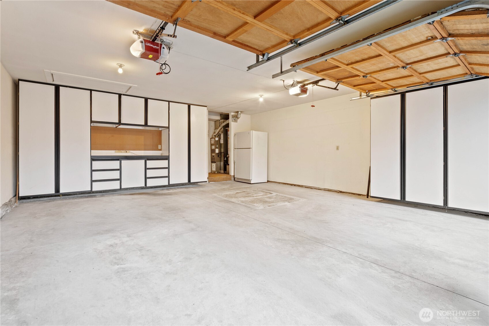 2 car garage with storage cabinets and attice storage