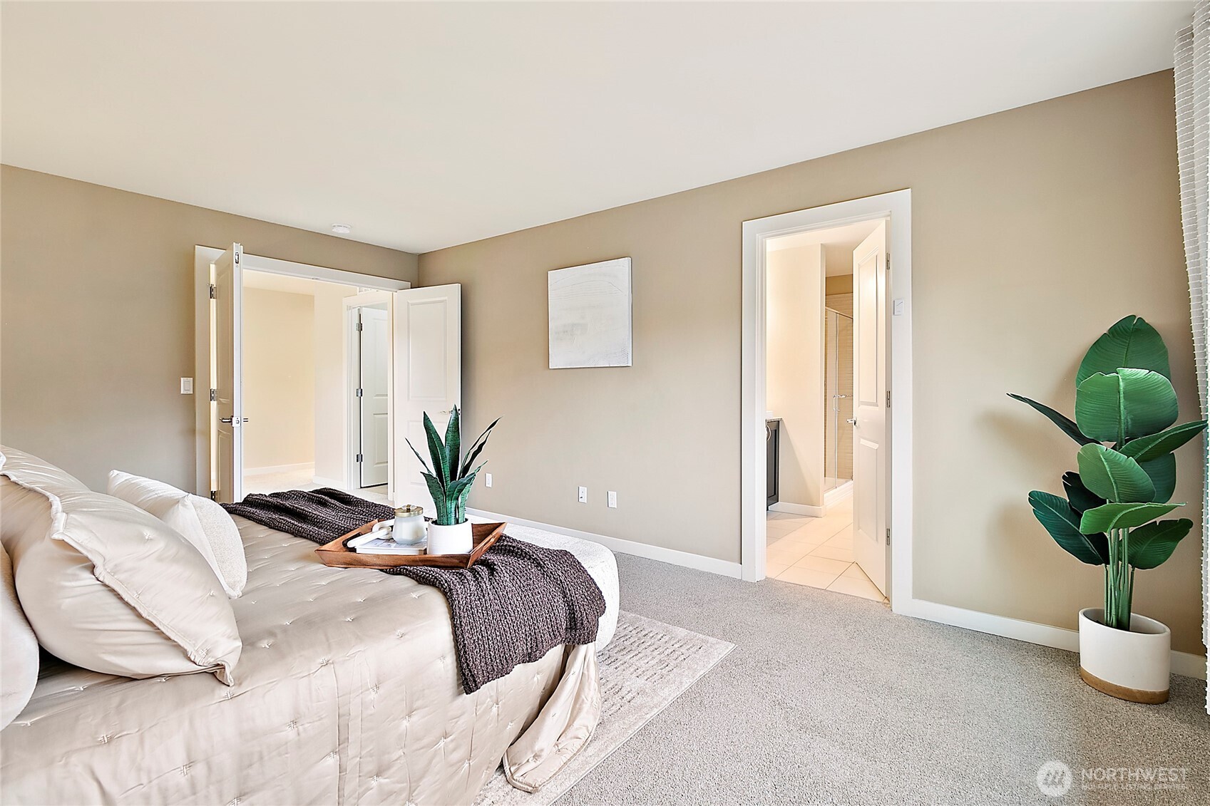 Double doors create a grand entrance to the spacious primary bedroom.