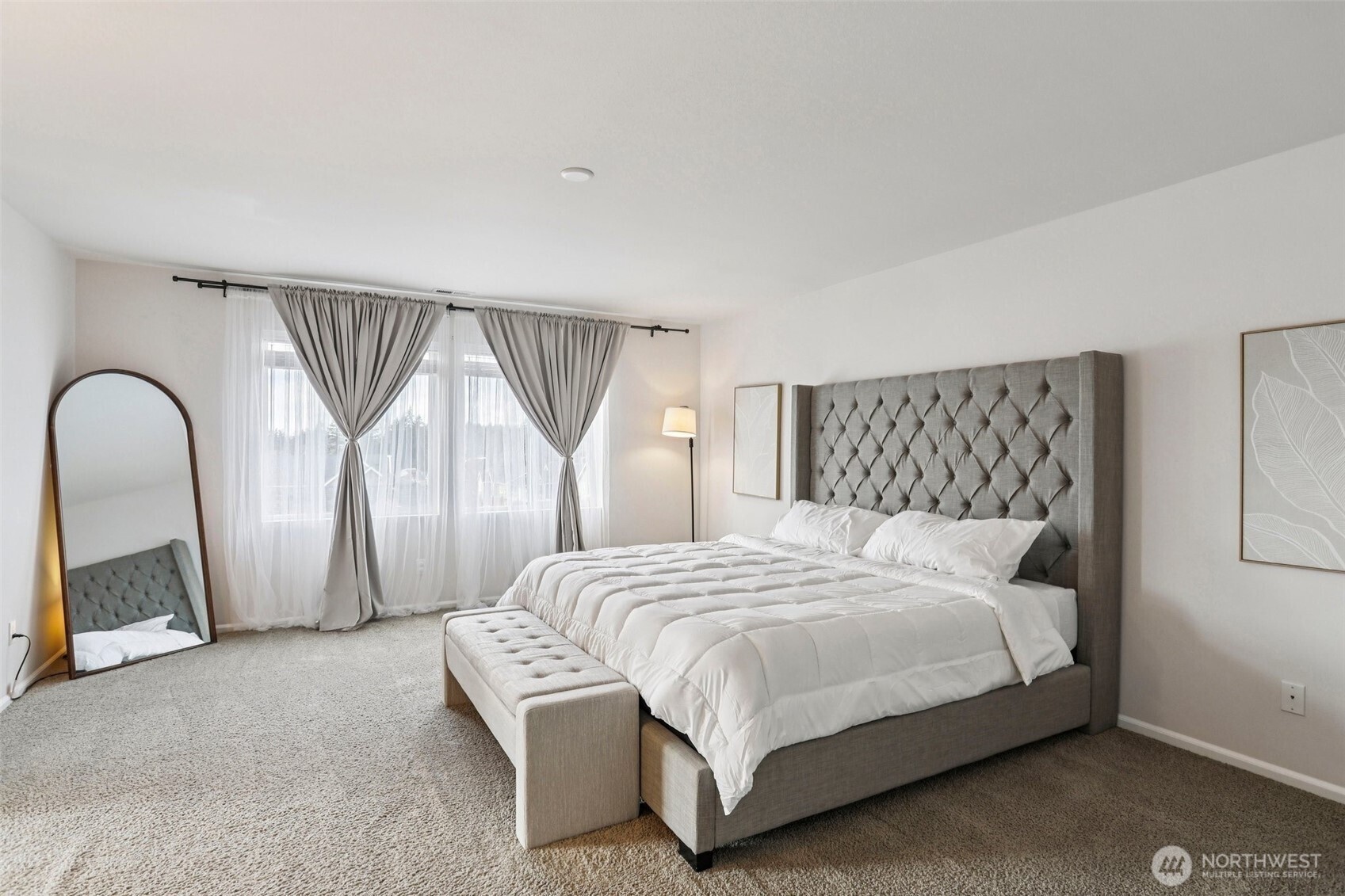 This expansive primary suite is designed for comfort and relaxation, boasting abundant natural light that floods the room, creating a warm and inviting atmosphere.