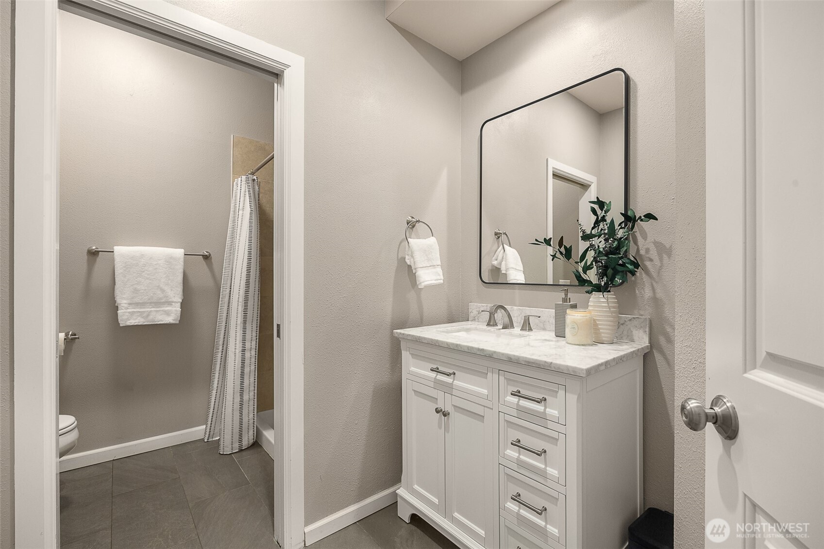 Bright, spa-inspired primary bathroom illuminated by skylights and expansive windows