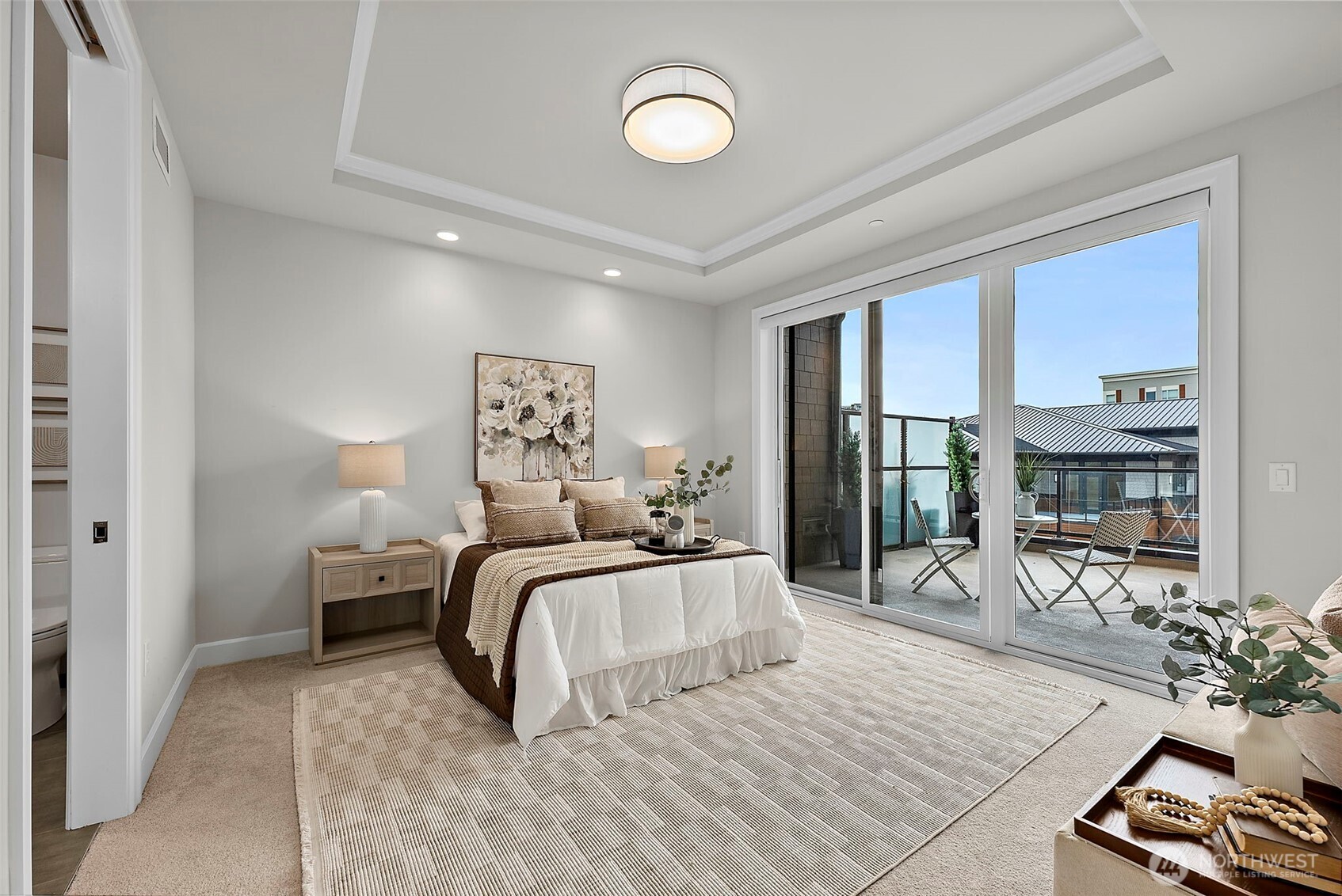 Primary bedroom suite with abundant natural light flowing from the glass slider that leads out to private balcony/deck.