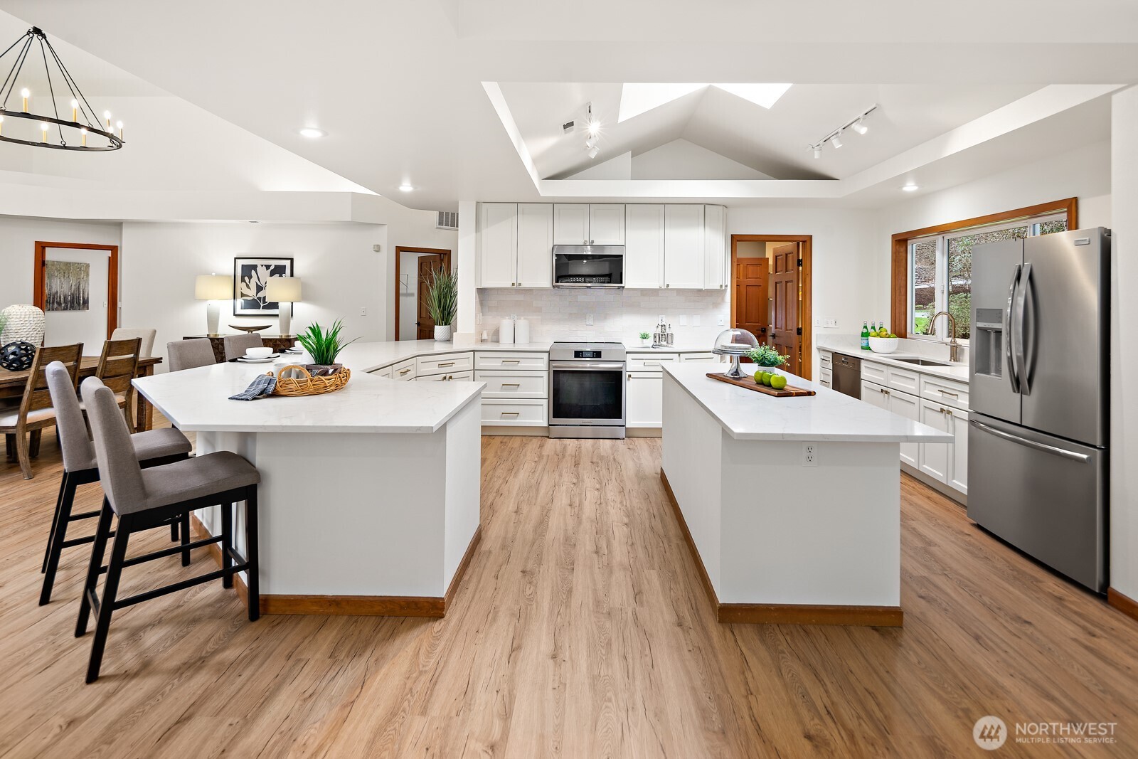 The remodeled chef's kitchen is complete with high end stainless appliances, quartz counters, custom cabinetry and a huge walk-thru pantry.