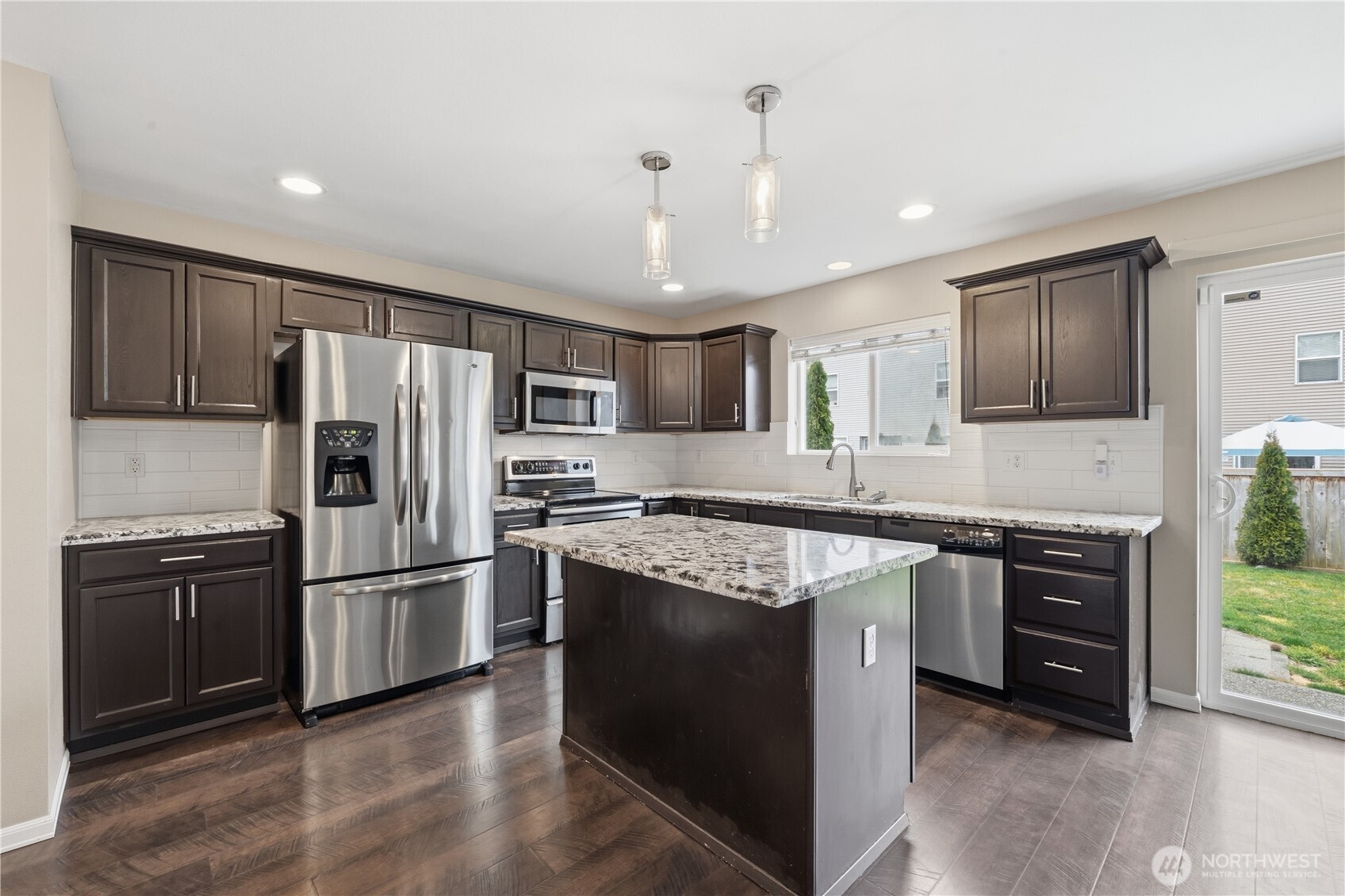 Kitchen with granite island and ample prep space.