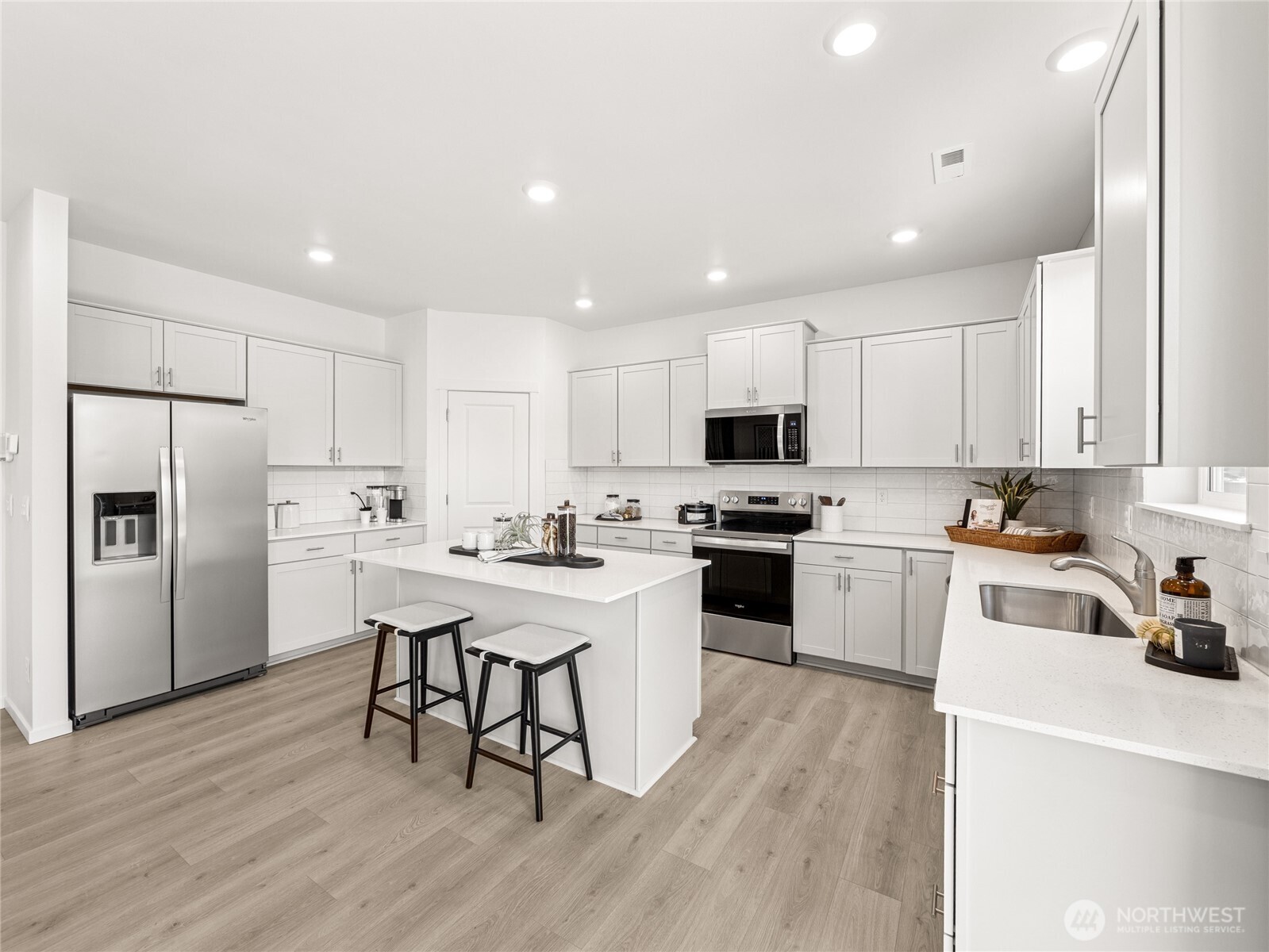 The family room boasts plenty of windows and light and features an electric fireplace, mantel above, and in wall wiring for your TV.  Picture for representational purposes only, colors and features may vary.