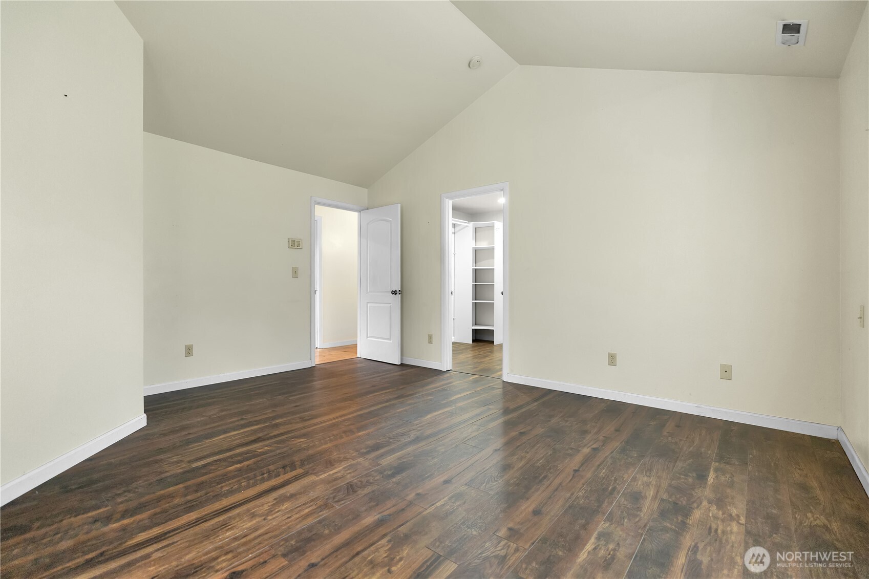 Vaulted ceilings in the primary bedroom creates an airy retreat with a sense of grandeur.