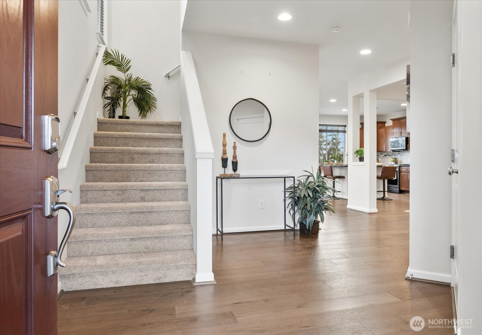 Tall ceilings and engineered hardwoods great you into the home.