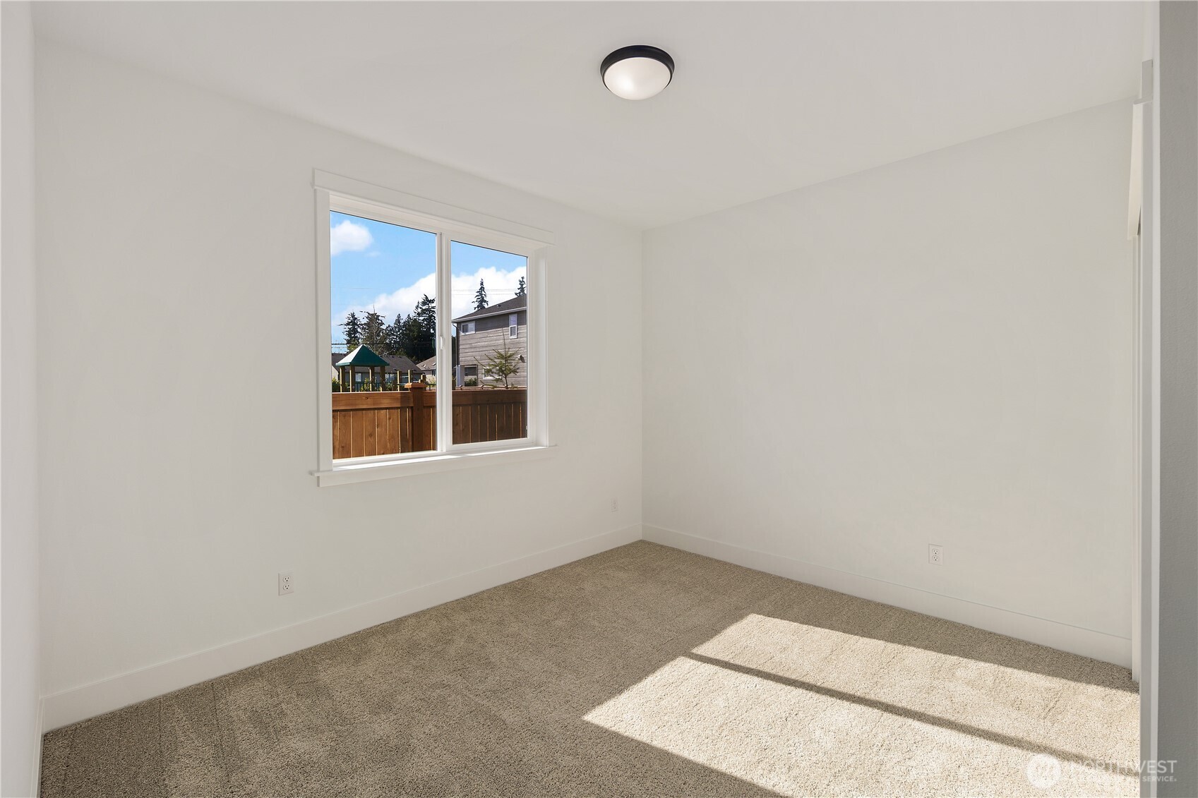 Main Level Den / Guest Bedroom  This main level den offers flexible living space with clean lines and abundant natural light. A large window frames the backyard outlook while soft carpeting and neutral tones create a comfortable setting for a home office, guest suite, or additional bedroom. The thoughtful placement on the main level enhances everyday convenience and accessibility.    Situated in Bothell, Washington near Canyon Park, this versatile room supports modern living within a Pacific Northwest contemporary home. The adaptable layout reflects the intentional design approach found in luxury new construction served by the Northshore School District.    These photos are from a past Robinson Plan at a different community, so overall plan, colors, building orientation, finishes, home outlook, and other details can and WILL vary. All photos, renderings, site maps, and floorplans are for visualization purposes only.