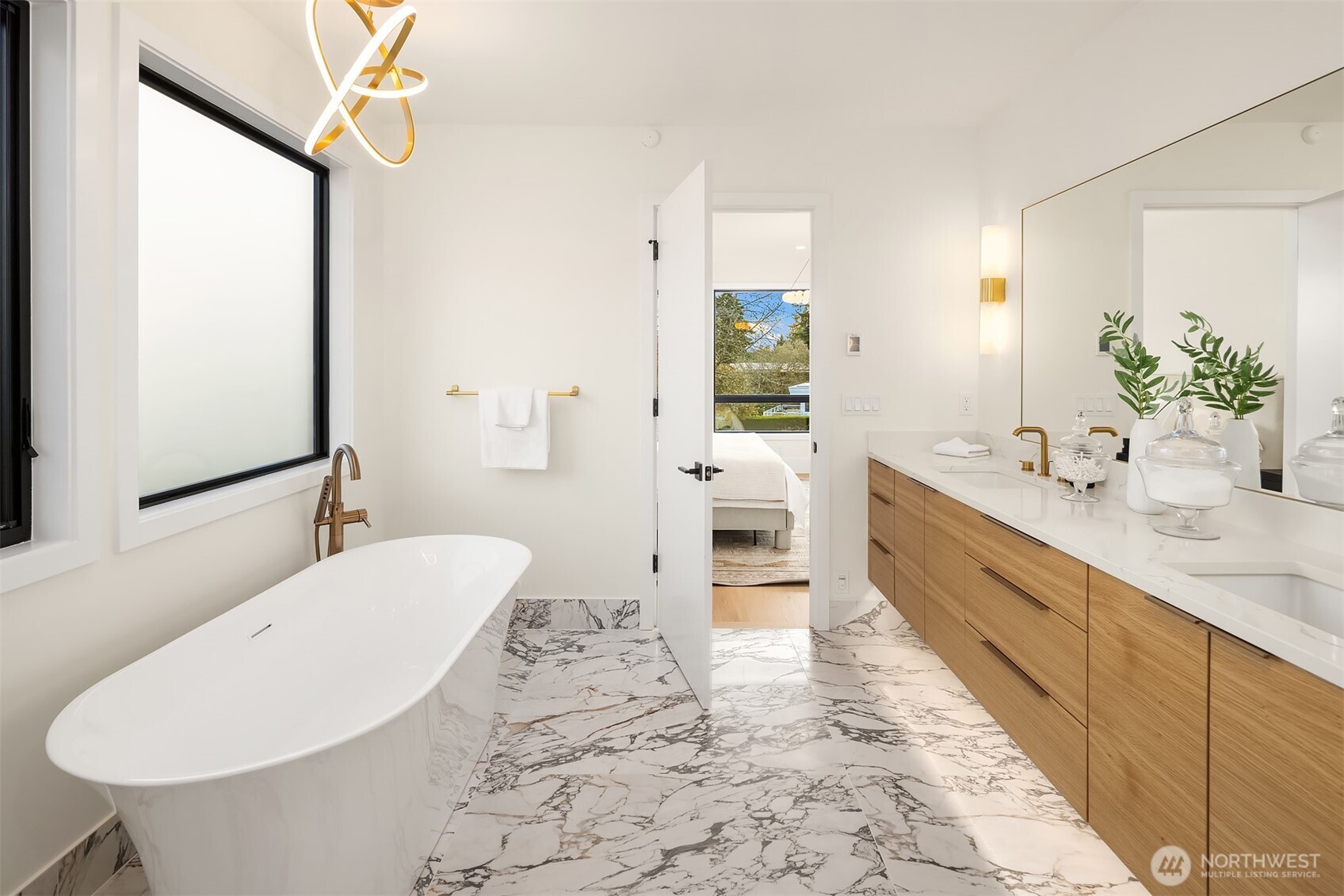 A spa-inspired bath featuring a curbless shower and marble tile.